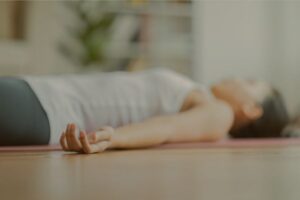 Woman relaxing in yoga Savasana (corpse pose)