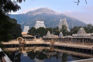 アシュラムの背後に広がるアルナーチャラ山を、淡い空色とピンクの雲がやさしく包む風景